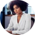 Donna con capelli afro in abito formale davanti a un computer