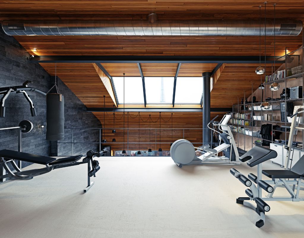 Spazio fitness in mansarda moderna dopo la ristrutturazione con soffitto in legno e attrezzi da palestra.